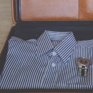 En randig skjorta och en klocka i en portfölj